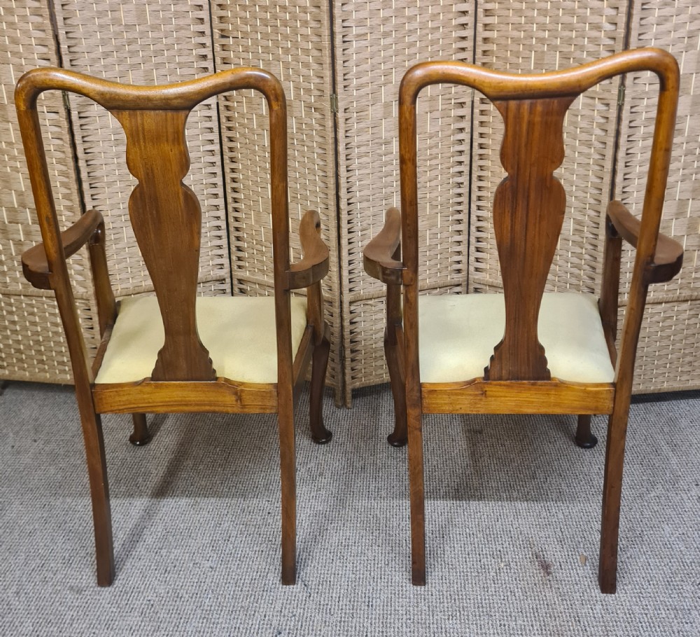 A pair of 1920s Queen Anne style walnut armchairs featuring vase-shaped splat backs, crook arms, cabriole legs with pad feet, and yellow velvet upholstered seats. View II