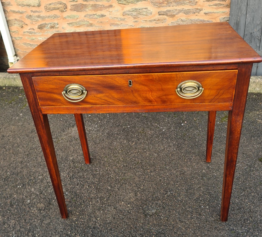 A Georgian mahogany side table featuring a full-width single drawer with brass oval handles and four square tapered legs.