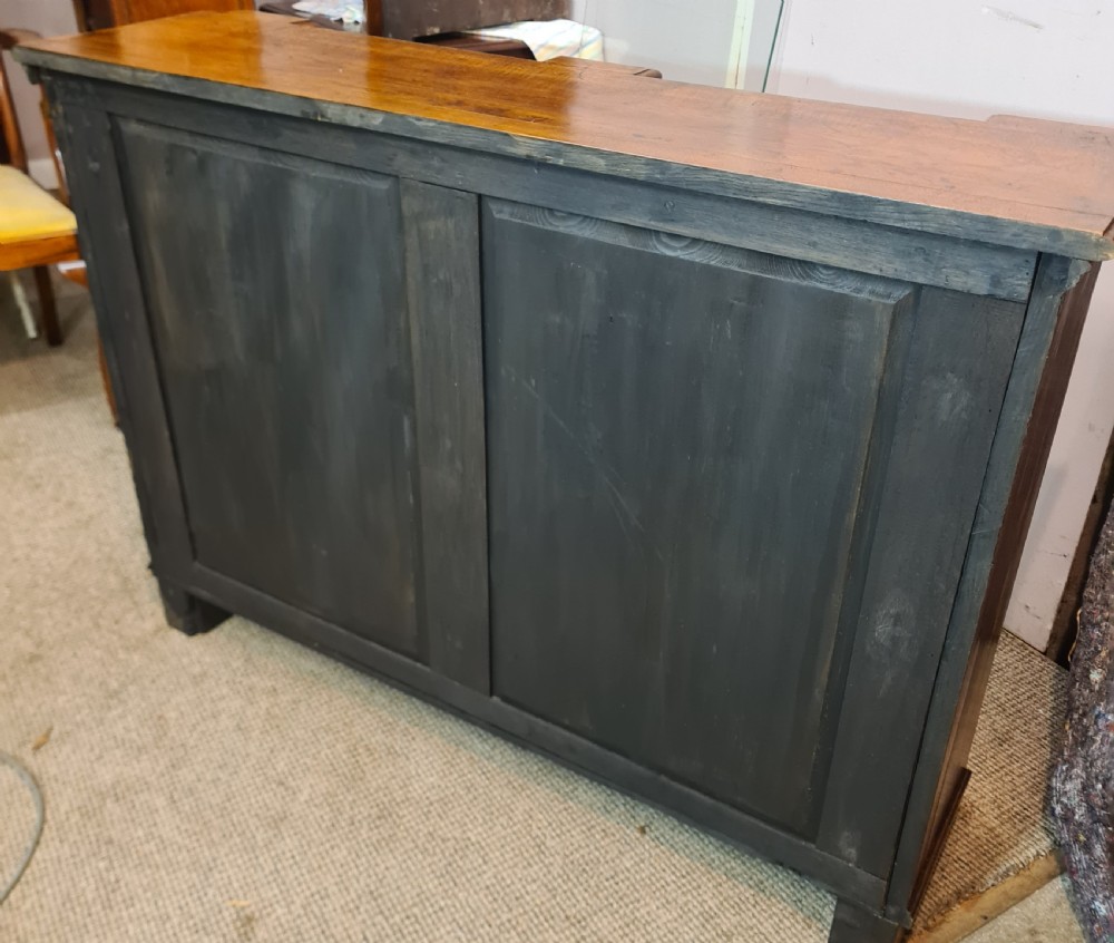 A low 19th-century open double bookcase made of dark stained oak with heavy carved corbels flanking two bays of shelves. View III