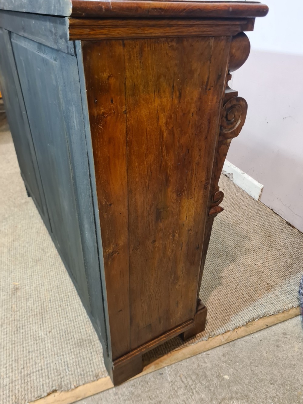 A low 19th-century open double bookcase made of dark stained oak with heavy carved corbels flanking two bays of shelves. View IX