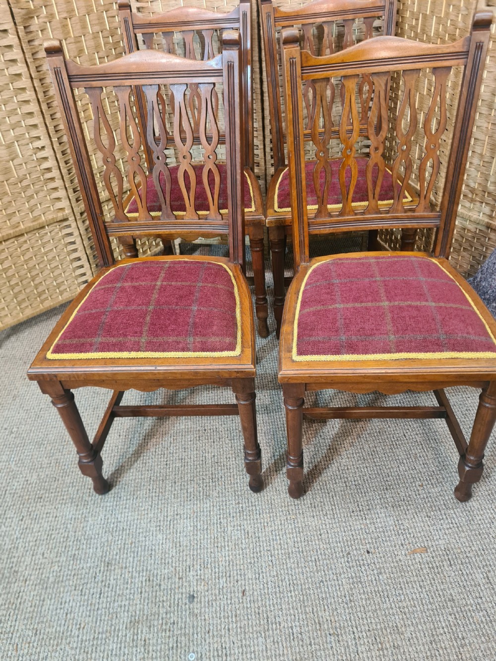 Set of six walnut Arts and Crafts dining chairs featuring pierced back slats, turned front legs, and red tartan upholstered seats with yellow trim. View II
