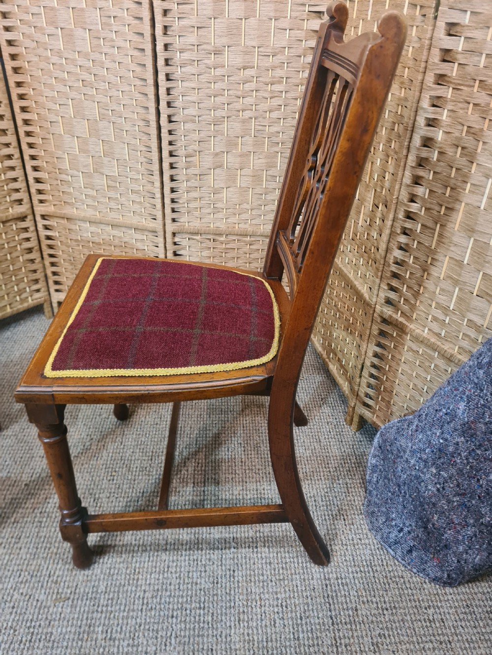 Set of six walnut Arts and Crafts dining chairs featuring pierced back slats, turned front legs, and red tartan upholstered seats with yellow trim. View IV