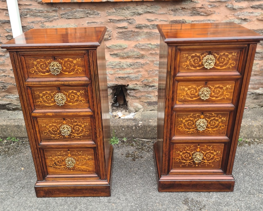 A pair of Victorian rosewood bedside cabinets featuring intricate floral marquetry inlays, four drawers each, and brass handles.
