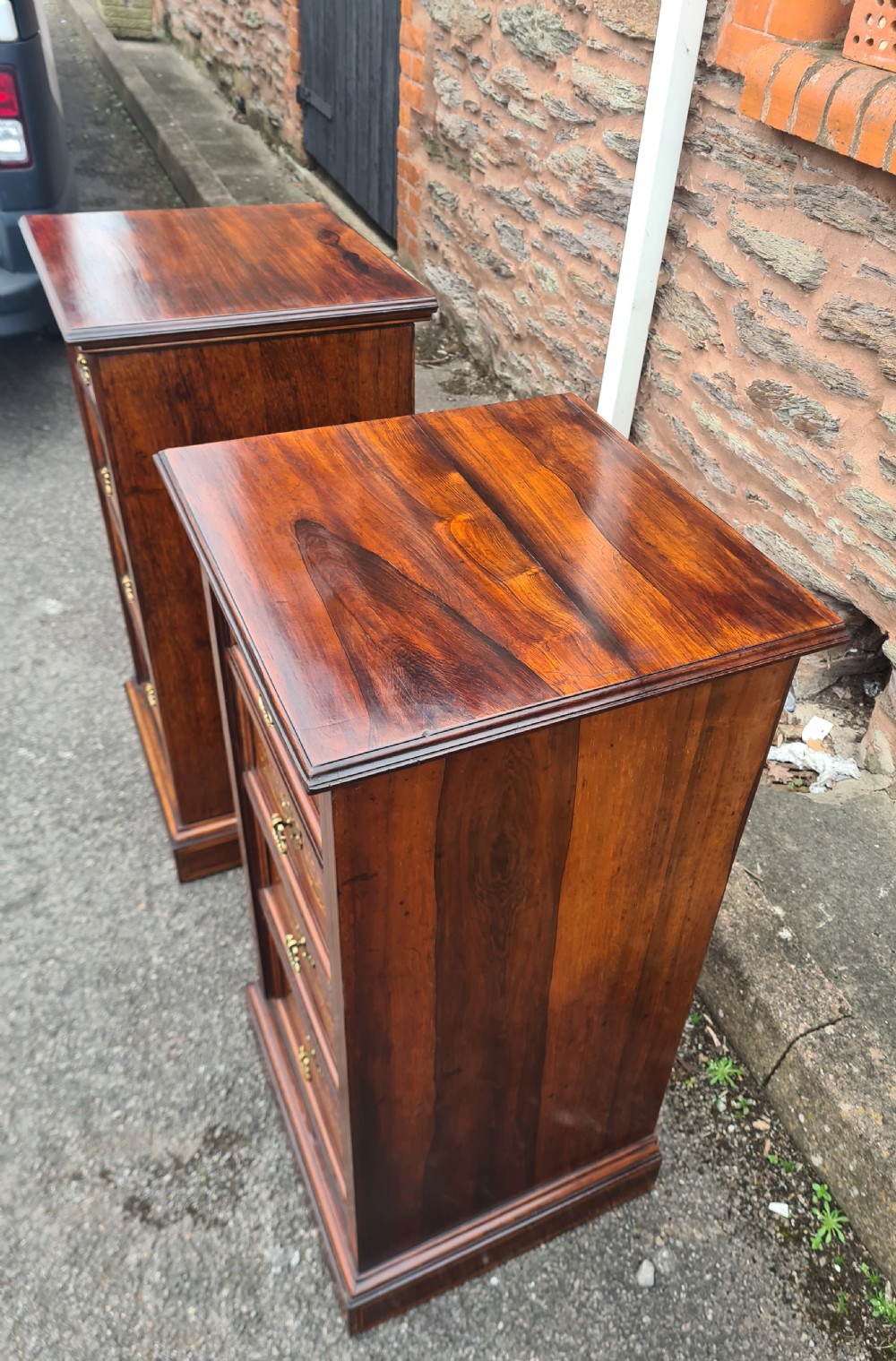A pair of Victorian rosewood bedside cabinets featuring intricate floral marquetry inlays, four drawers each, and brass handles. View V