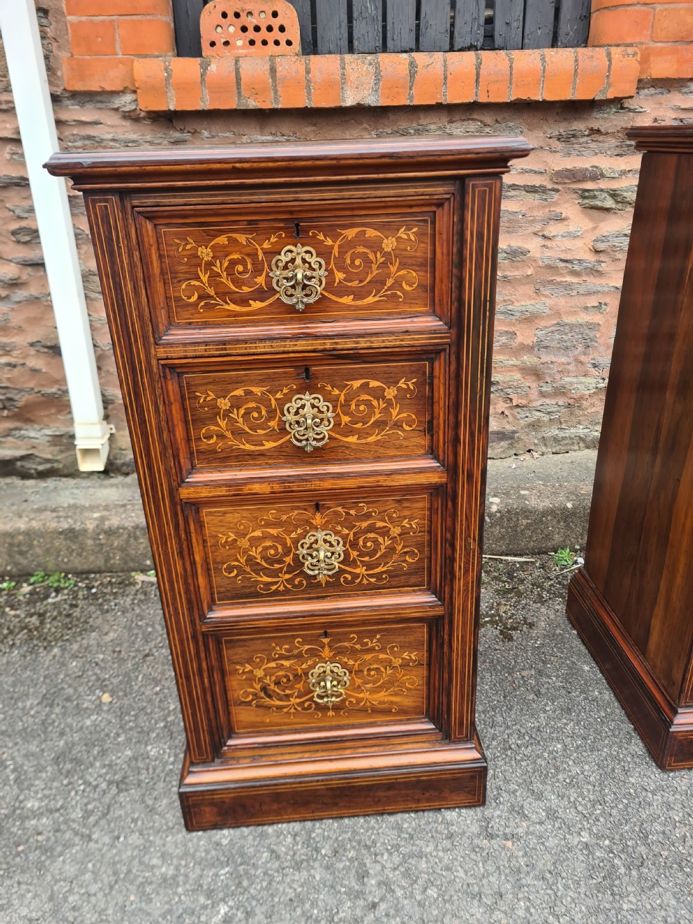 A pair of Victorian rosewood bedside cabinets featuring intricate floral marquetry inlays, four drawers each, and brass handles. View VII