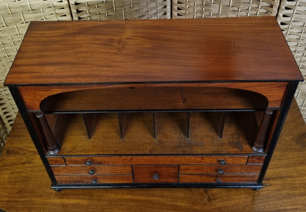 A nineteenth-century mahogany tabletop stationery cabinet featuring an open upper compartment with pigeonholes and turned side columns above six small drawers with dark turned knobs. View III