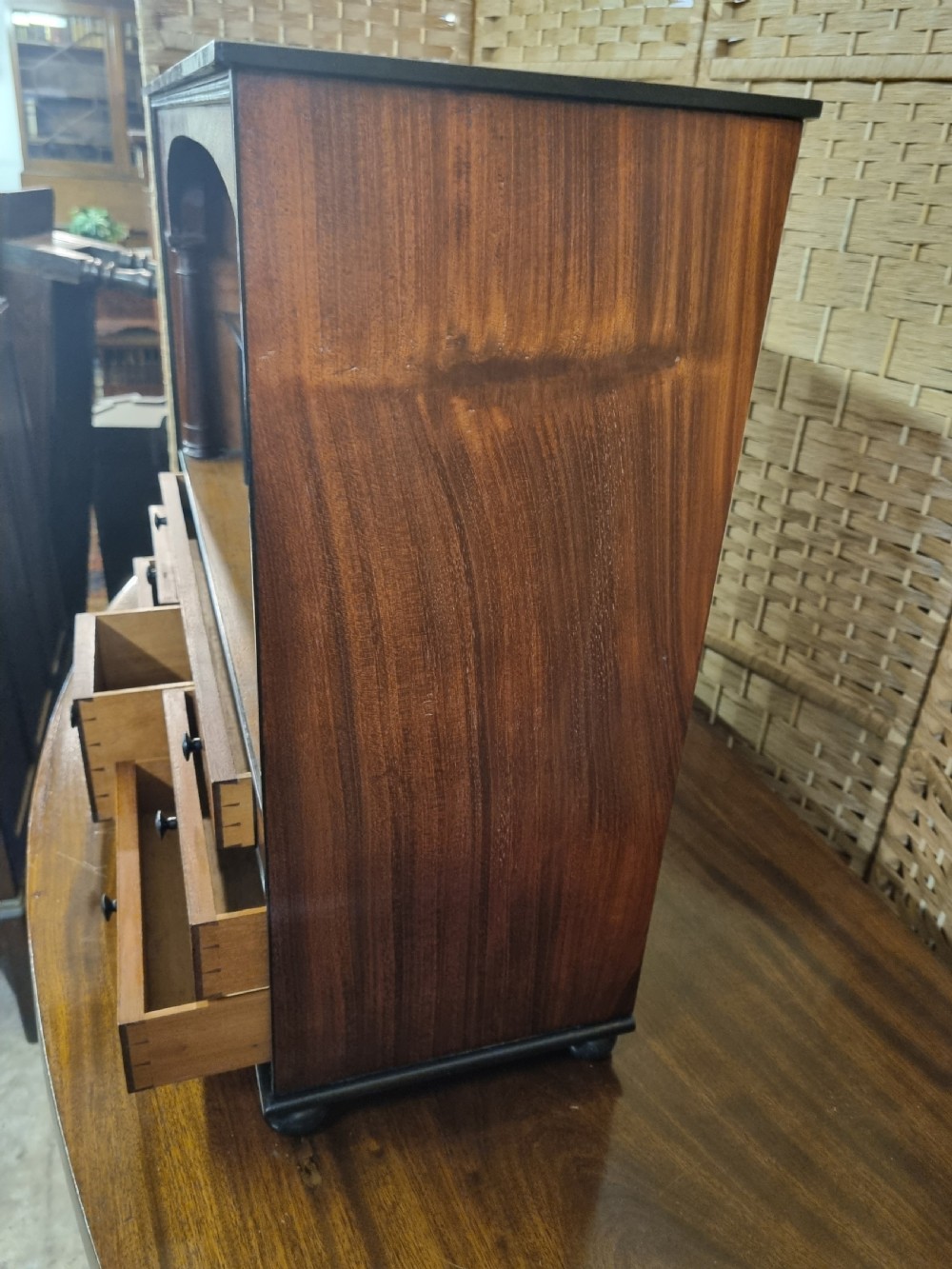 A nineteenth-century mahogany tabletop stationery cabinet featuring an open upper compartment with pigeonholes and turned side columns above six small drawers with dark turned knobs. View V