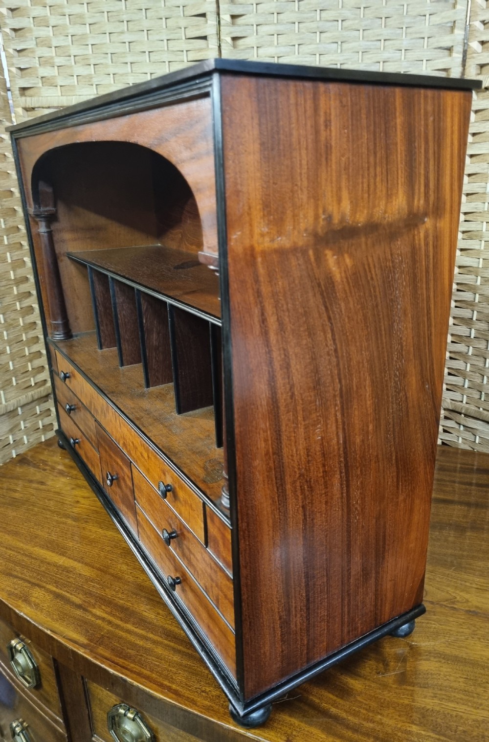 A nineteenth-century mahogany tabletop stationery cabinet featuring an open upper compartment with pigeonholes and turned side columns above six small drawers with dark turned knobs. View VI
