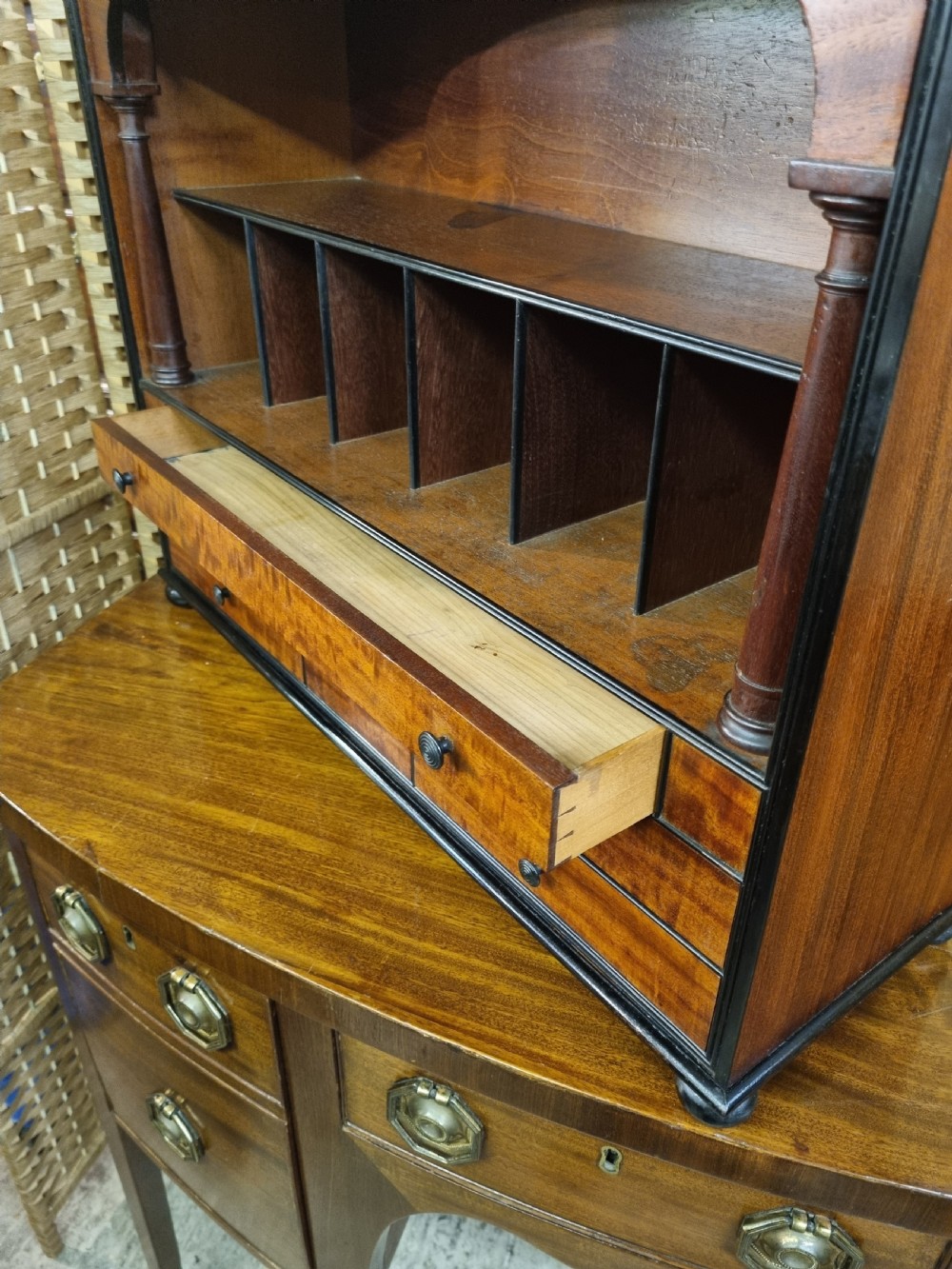 A nineteenth-century mahogany tabletop stationery cabinet featuring an open upper compartment with pigeonholes and turned side columns above six small drawers with dark turned knobs. View VII