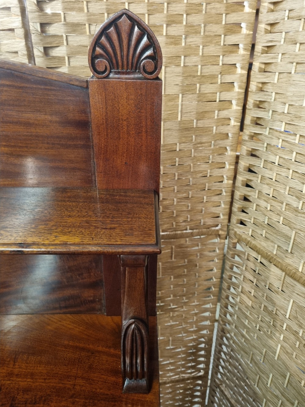 An early nineteenth-century flame mahogany chiffonier featuring a carved cresting backboard with a single shelf over a two-door cabinet flanked by turned columns. View II