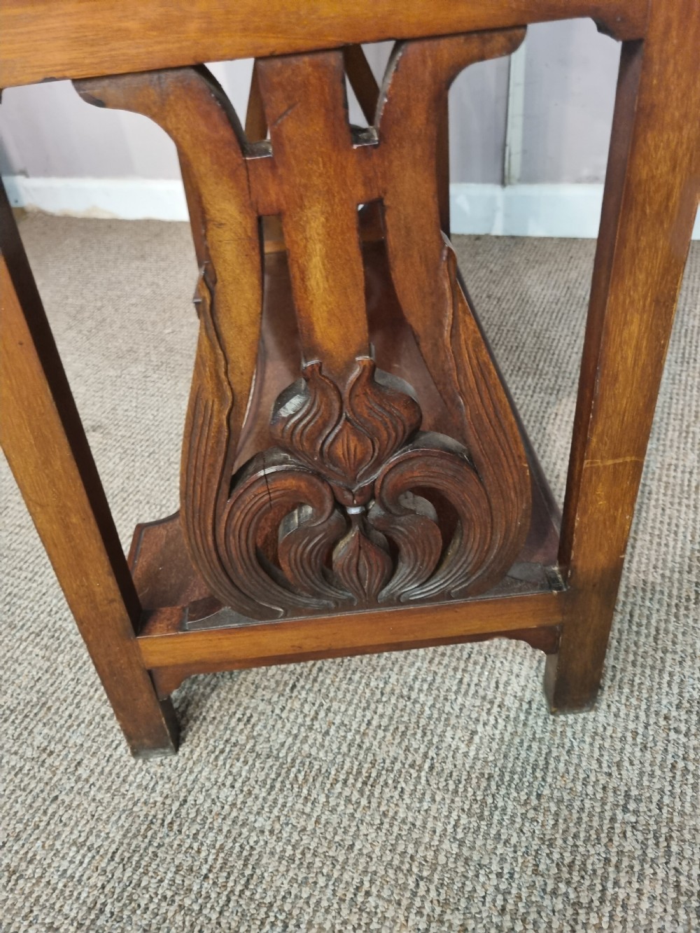An Arts and Crafts mahogany bureau cabinet featuring a carved fall front slope, glazed upper cupboard doors, brass handles, and a lower shelf. View VI