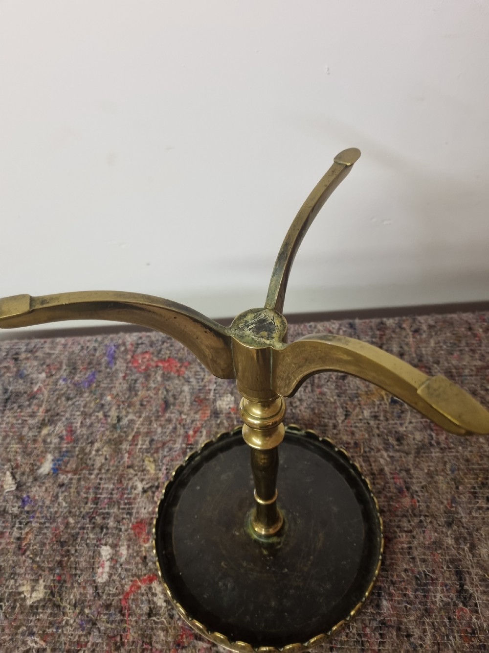 A Georgian cast brass kettle stand featuring a circular top with a scalloped rim, a turned baluster stem, and a tripod base. View III