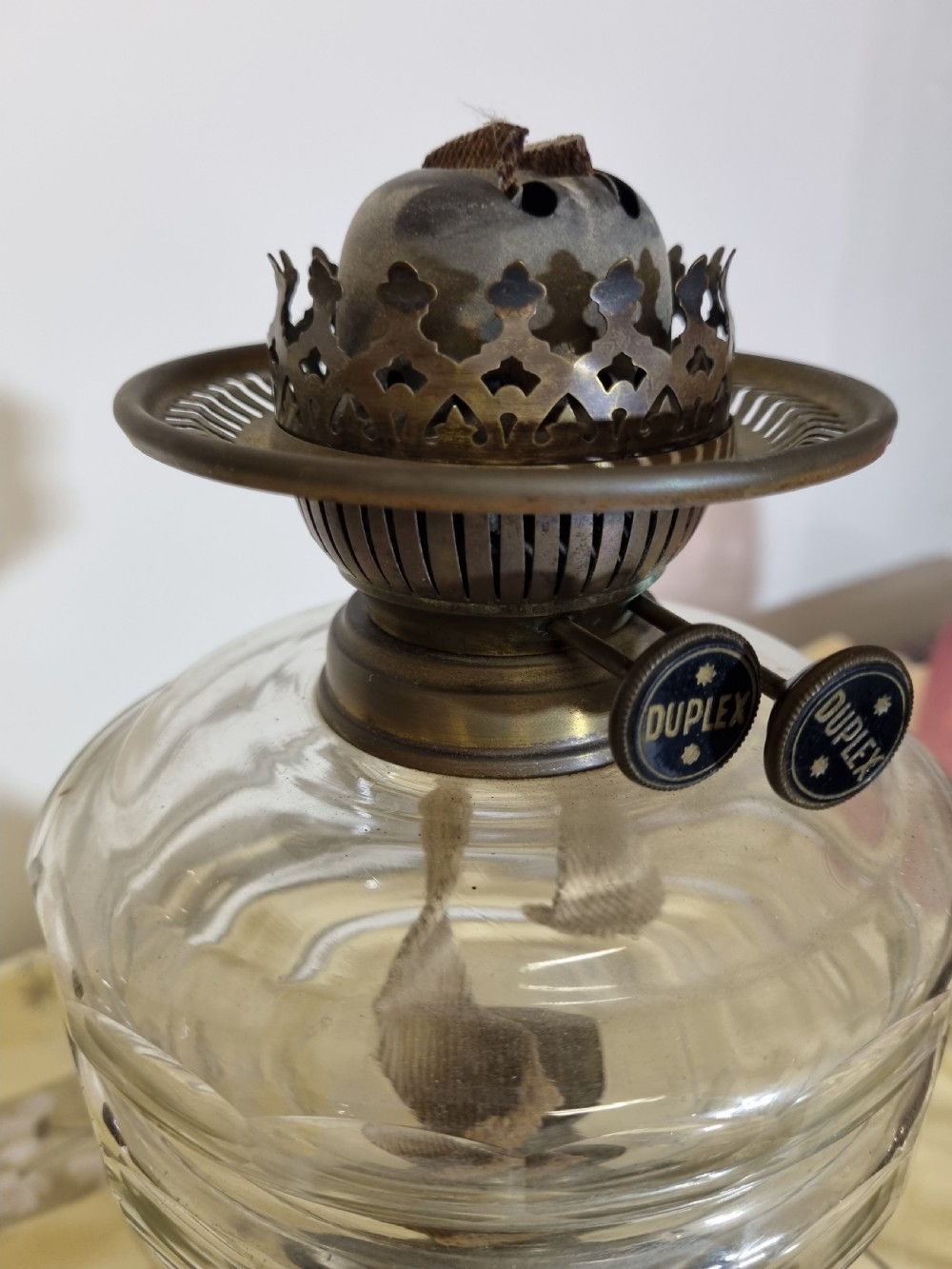A Victorian oil lamp featuring an etched pink glass shade, clear glass reservoir, brass duplex burner, and black plinth base. View III