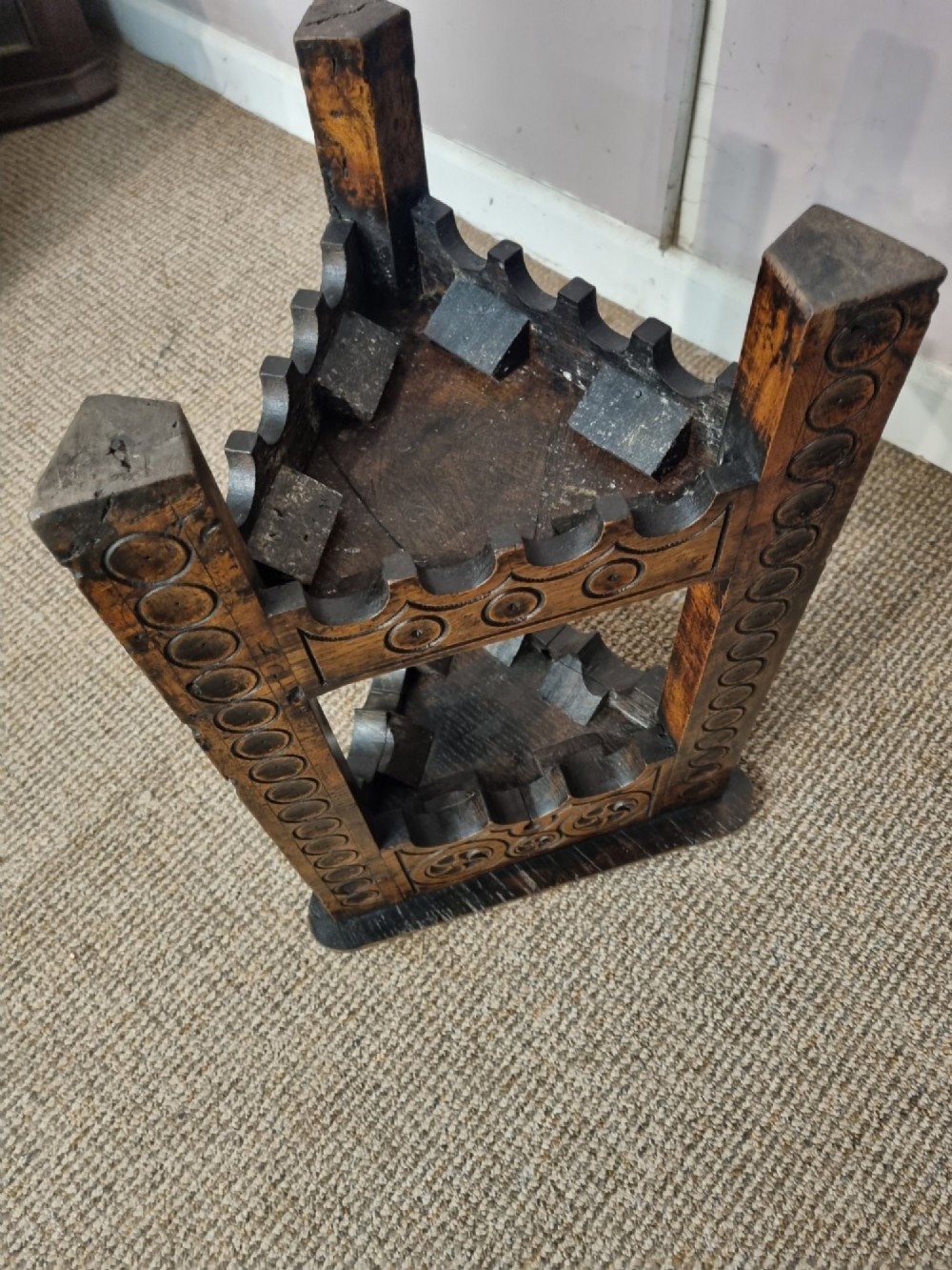 An early nineteenth-century dark carved oak triangular side table with a hinged top, lower shelf, and circular wheel carving details. View VI