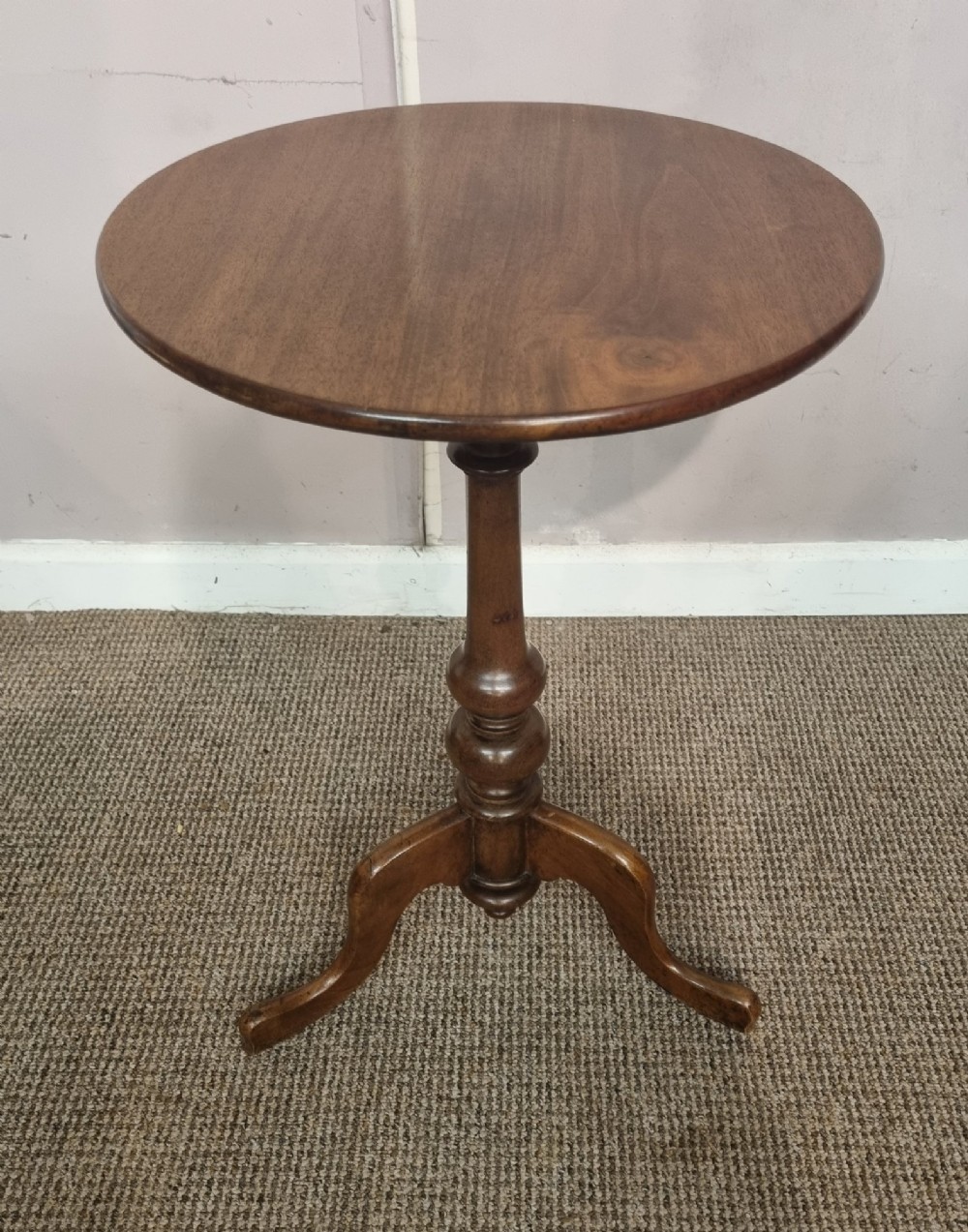A Victorian mahogany tripod table with a circular top, turned central column, and three splayed legs.