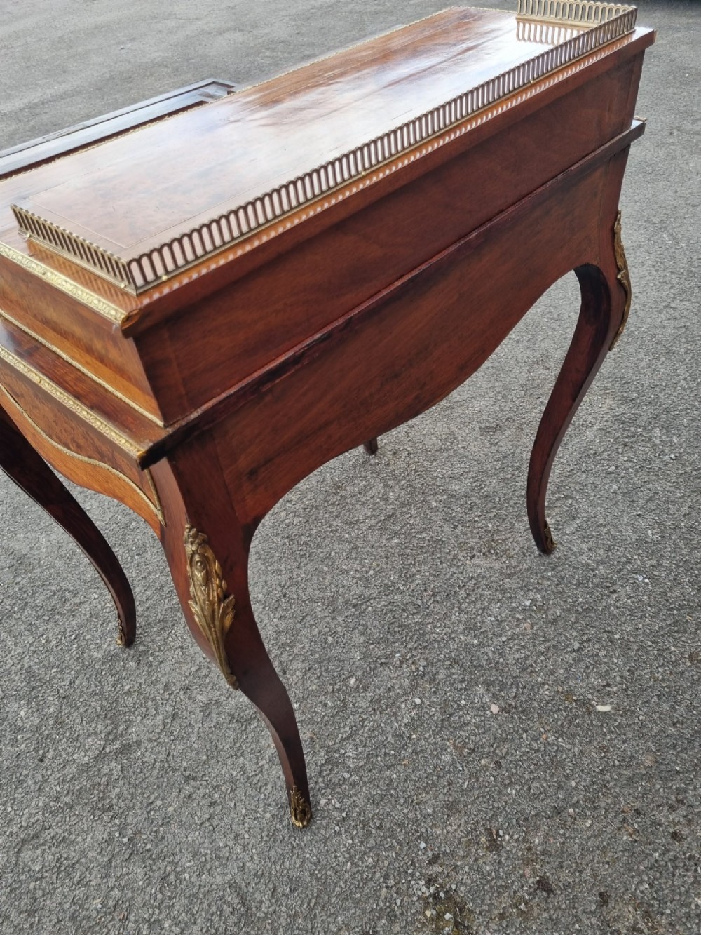 A nineteenth-century rosewood and amboyna veneer bonheur du jour desk featuring cabriole legs, gilt-metal mounts, and a brass gallery rail on the raised upper shelf. View VII