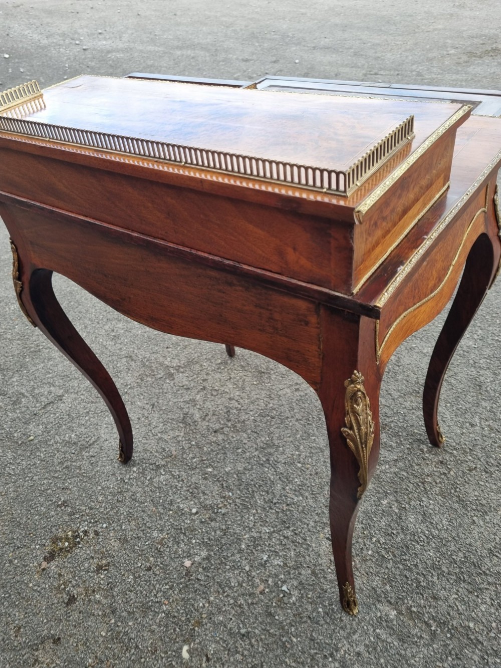 A nineteenth-century rosewood and amboyna veneer bonheur du jour desk featuring cabriole legs, gilt-metal mounts, and a brass gallery rail on the raised upper shelf. View VIII