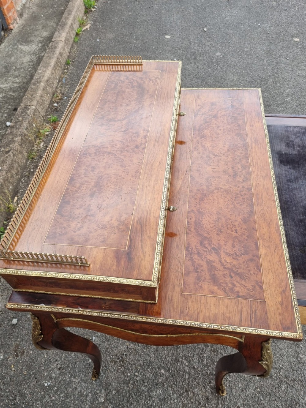 A nineteenth-century rosewood and amboyna veneer bonheur du jour desk featuring cabriole legs, gilt-metal mounts, and a brass gallery rail on the raised upper shelf. View IX