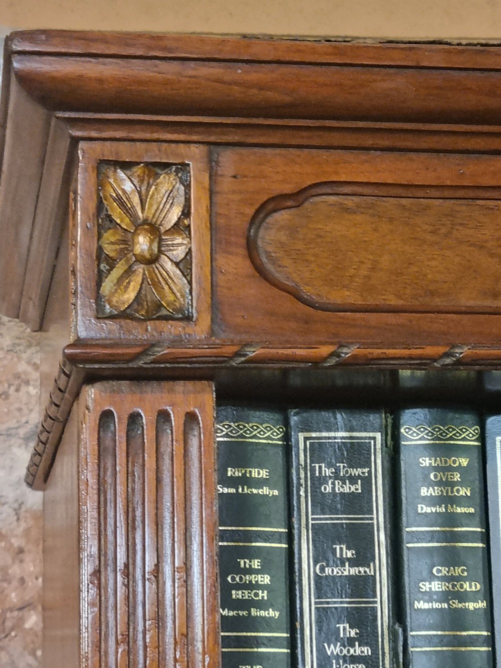 An Edwardian walnut breakfront open bookcase with three fitted sections, carved patera details, and fluted pilasters. View VI