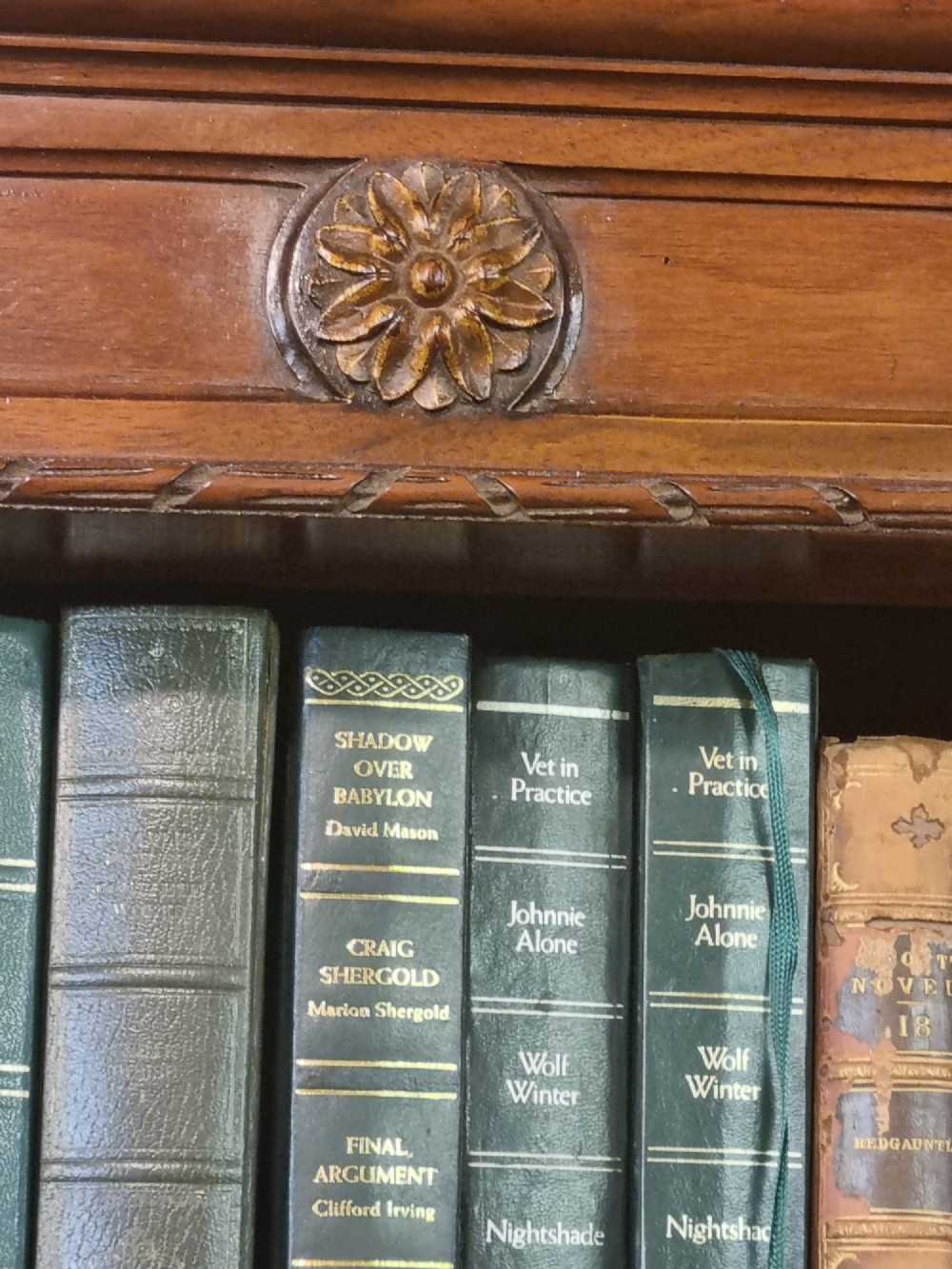 An Edwardian walnut breakfront open bookcase with three fitted sections, carved patera details, and fluted pilasters. View VIII