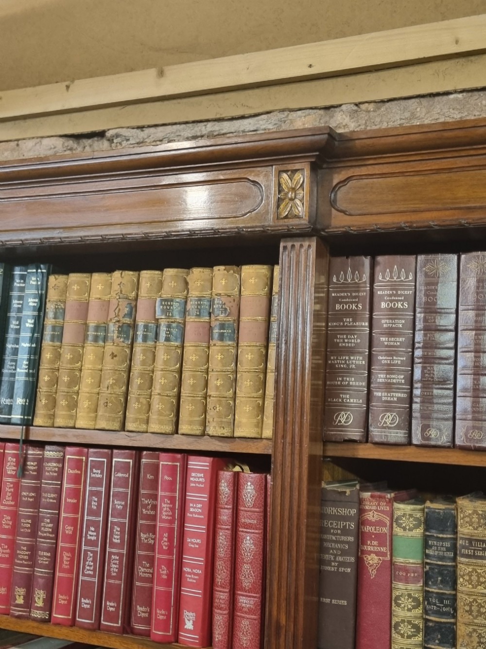 An Edwardian walnut breakfront open bookcase with three fitted sections, carved patera details, and fluted pilasters. View IX