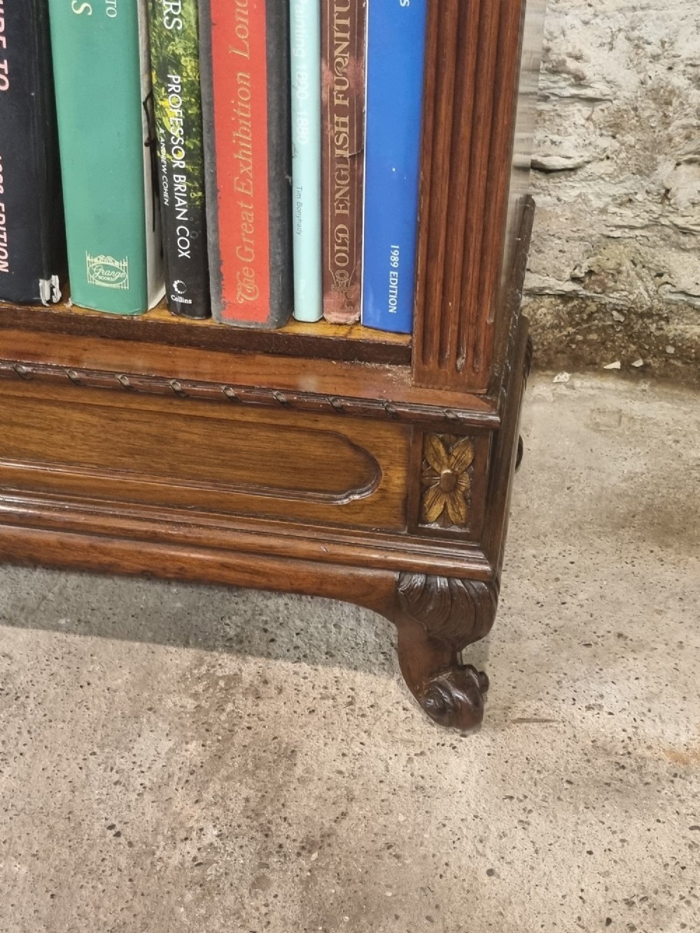 An Edwardian walnut breakfront open bookcase with three fitted sections, carved patera details, and fluted pilasters. View XI