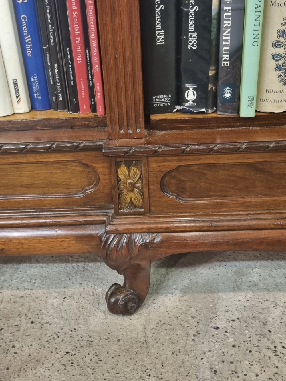 An Edwardian walnut breakfront open bookcase with three fitted sections, carved patera details, and fluted pilasters. View XIV