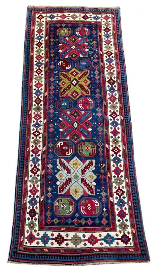 fig 1. An antique Caucasian Talish long rug featuring a navy blue central field decorated with red and green geometric star medallions within an ivory patterned border.