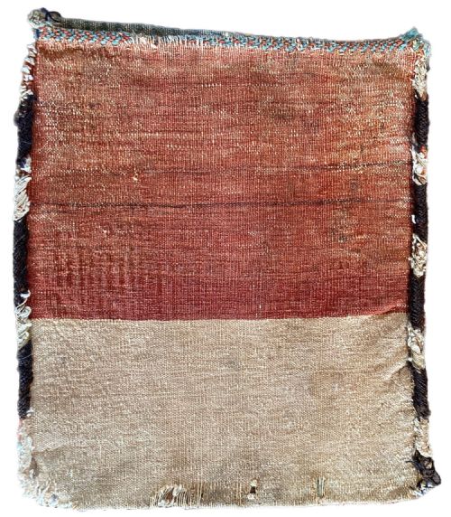 fig 1. An antique hand-knotted Kurdish chanteh bag face featuring diagonal chevron stripes in terracotta red and teal blue bordered by a geometric motif.