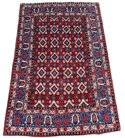 fig 1. An antique Veramin Persian rug featuring a red central field filled with a repeating floral lattice pattern enclosed by a dark blue border.