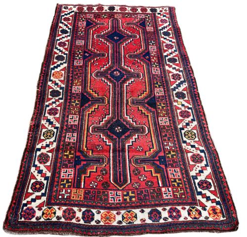 fig 1. A hand-knotted antique Lori wool rug featuring a central stepped pole medallion in dark blue and red on a red field with geometric borders.