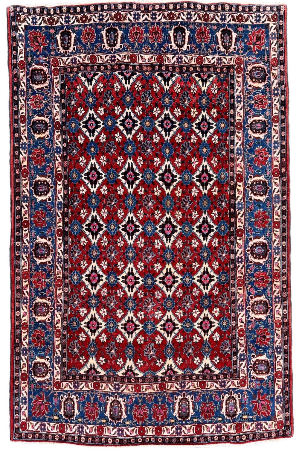 An antique Veramin Persian rug featuring a red central field filled with a repeating floral lattice pattern enclosed by a dark blue border.