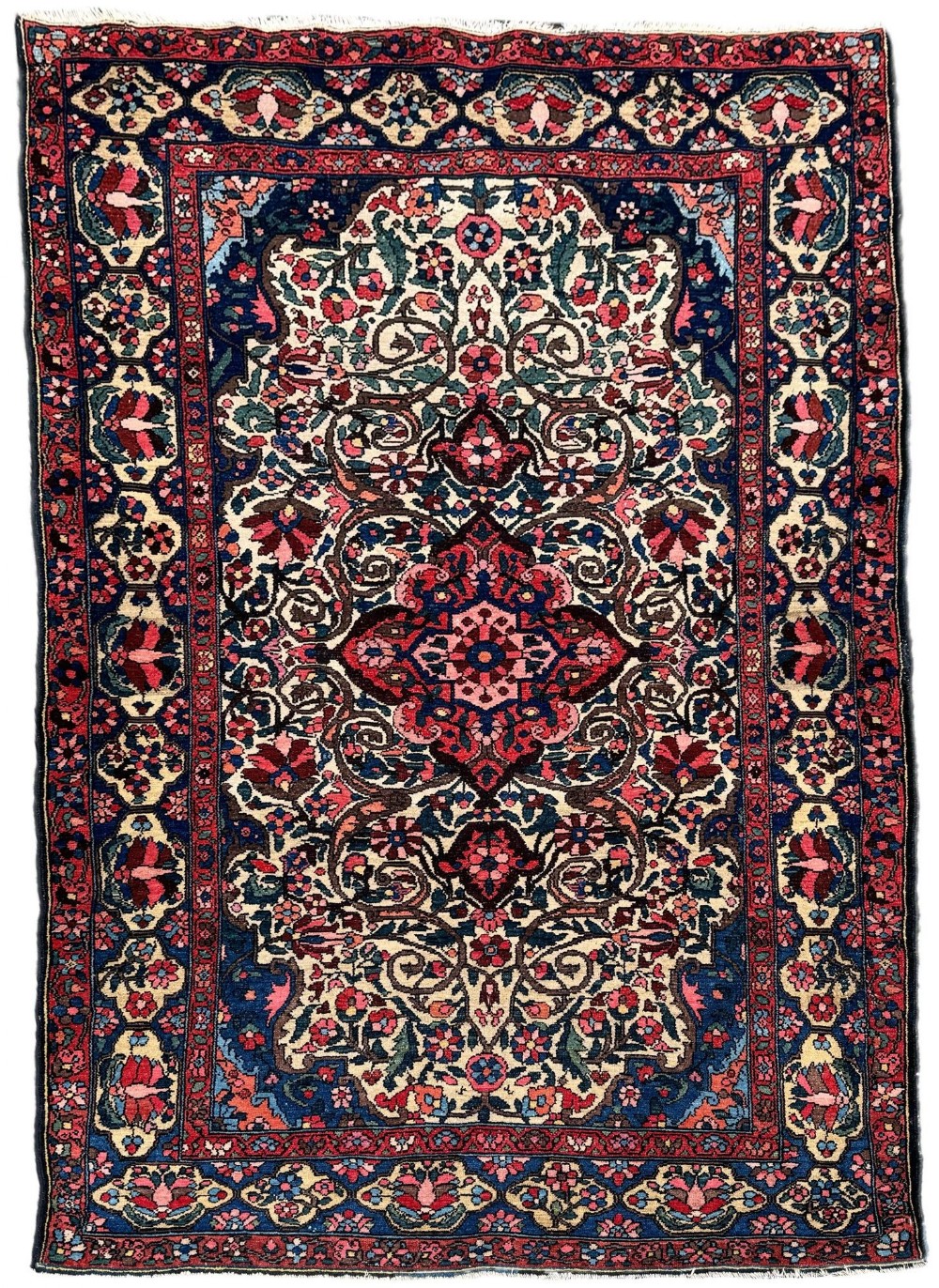 An antique hand-knotted Bakhtiar wool area rug featuring a central starburst medallion surrounded by intricate floral scrolling patterns in navy blue, red, cream, and green shades with a multi-layered border.