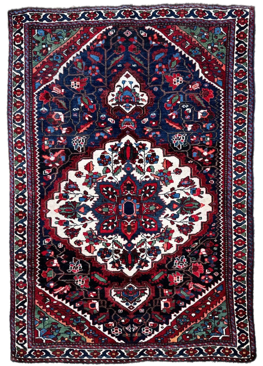 An antique handwoven Luri rug featuring horizontal polychrome stripes in terracotta, green, blue, and yellow with small geometric motifs.