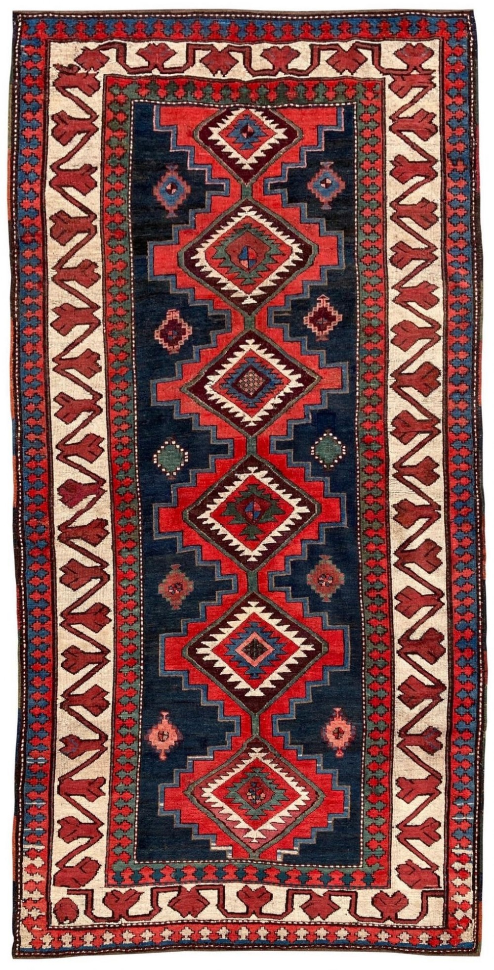 An antique Caucasian Kazak wool rug featuring repeating geometric diamond medallions in red, navy blue, green, and ivory framed by stepped borders.