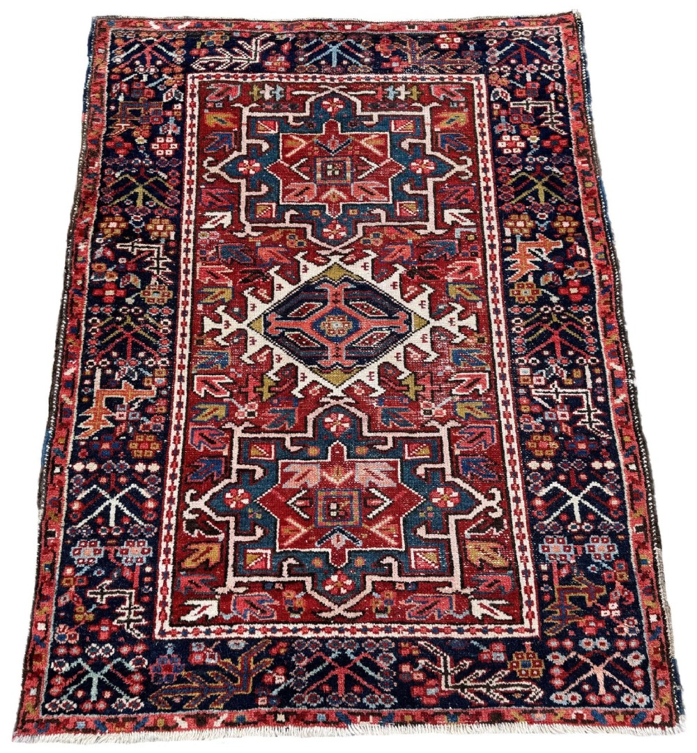 An antique hand-knotted Karaja wool rug featuring three distinct geometric medallions in red, navy blue, and ivory tones surrounded by a dense tribal border. View II
