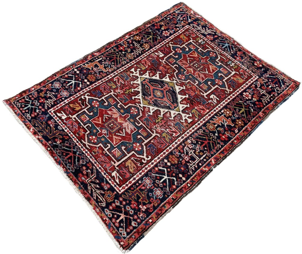 An antique hand-knotted Karaja wool rug featuring three distinct geometric medallions in red, navy blue, and ivory tones surrounded by a dense tribal border. View III