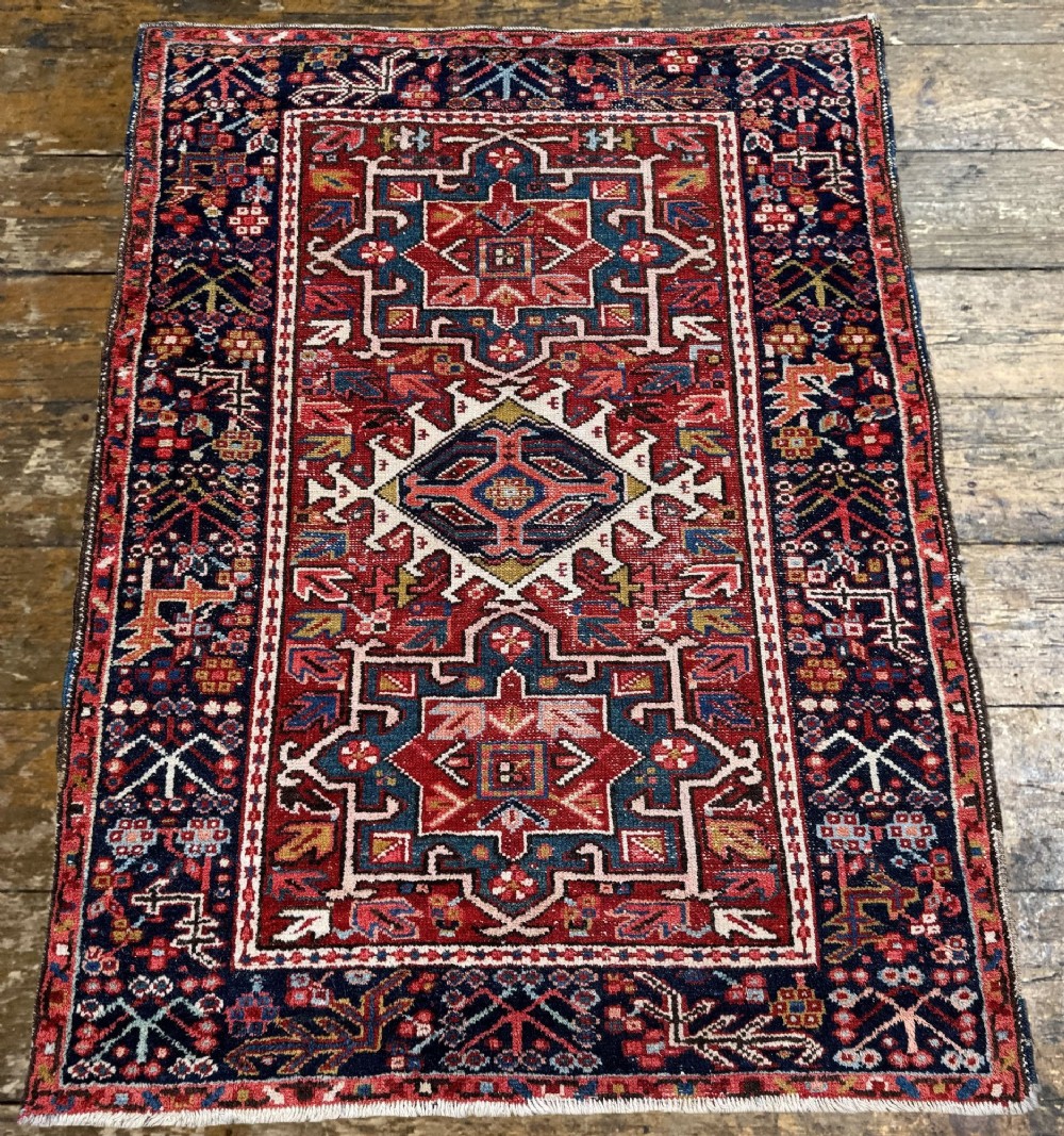 An antique hand-knotted Karaja wool rug featuring three distinct geometric medallions in red, navy blue, and ivory tones surrounded by a dense tribal border. View IV