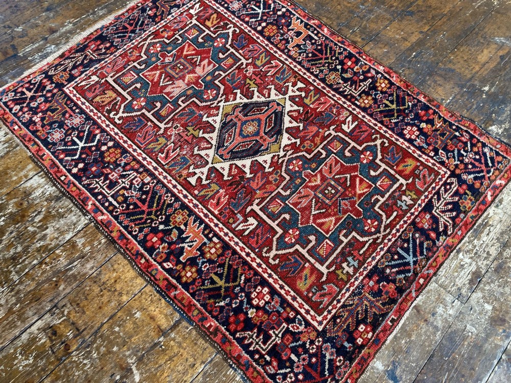 An antique hand-knotted Karaja wool rug featuring three distinct geometric medallions in red, navy blue, and ivory tones surrounded by a dense tribal border. View VI
