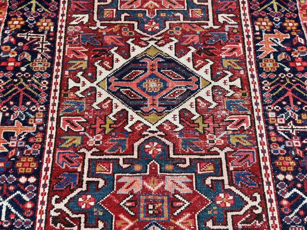 An antique hand-knotted Karaja wool rug featuring three distinct geometric medallions in red, navy blue, and ivory tones surrounded by a dense tribal border. View VIII