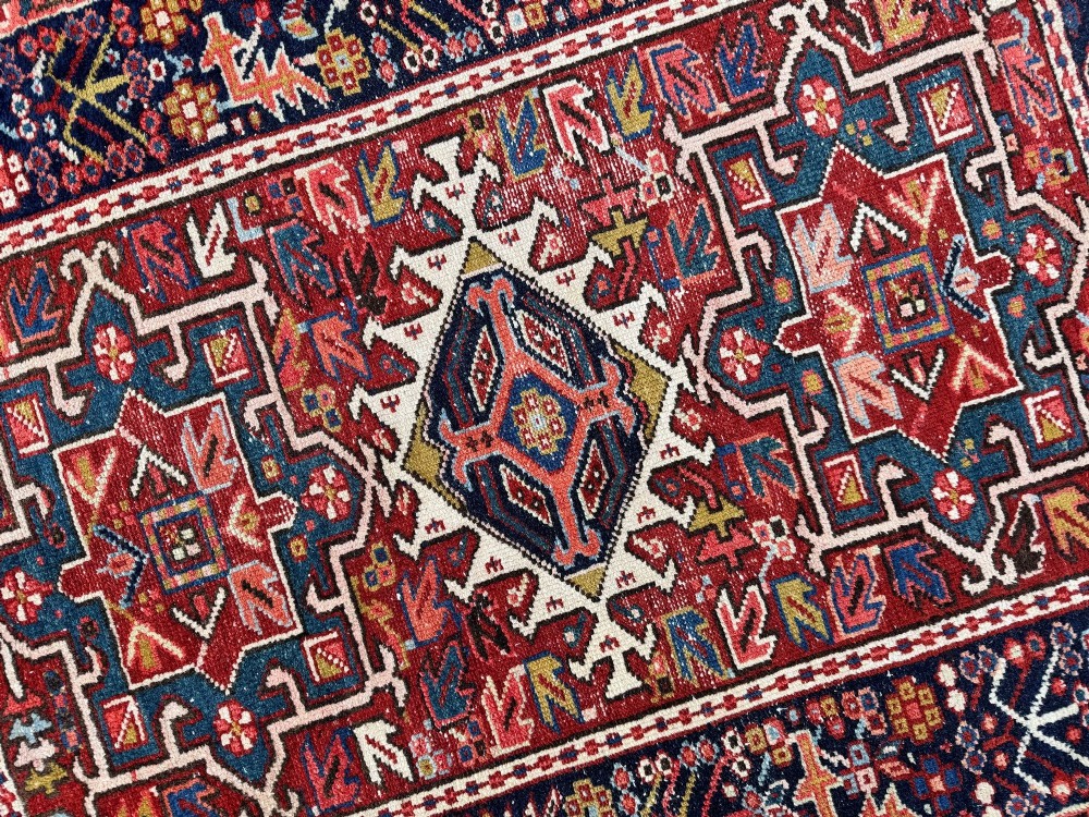 An antique hand-knotted Karaja wool rug featuring three distinct geometric medallions in red, navy blue, and ivory tones surrounded by a dense tribal border. View XI