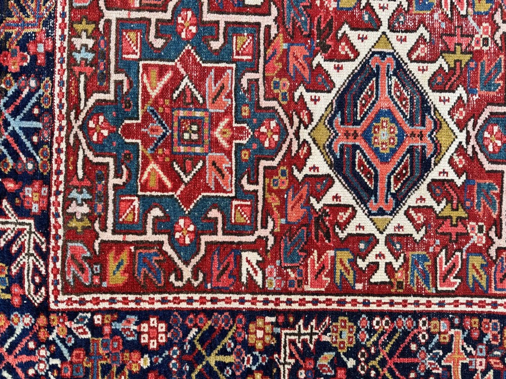 An antique hand-knotted Karaja wool rug featuring three distinct geometric medallions in red, navy blue, and ivory tones surrounded by a dense tribal border. View XII