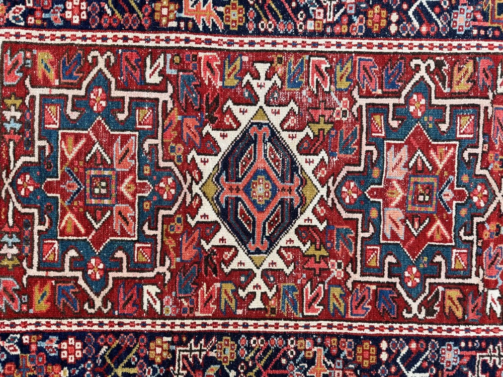 An antique hand-knotted Karaja wool rug featuring three distinct geometric medallions in red, navy blue, and ivory tones surrounded by a dense tribal border. View XIV