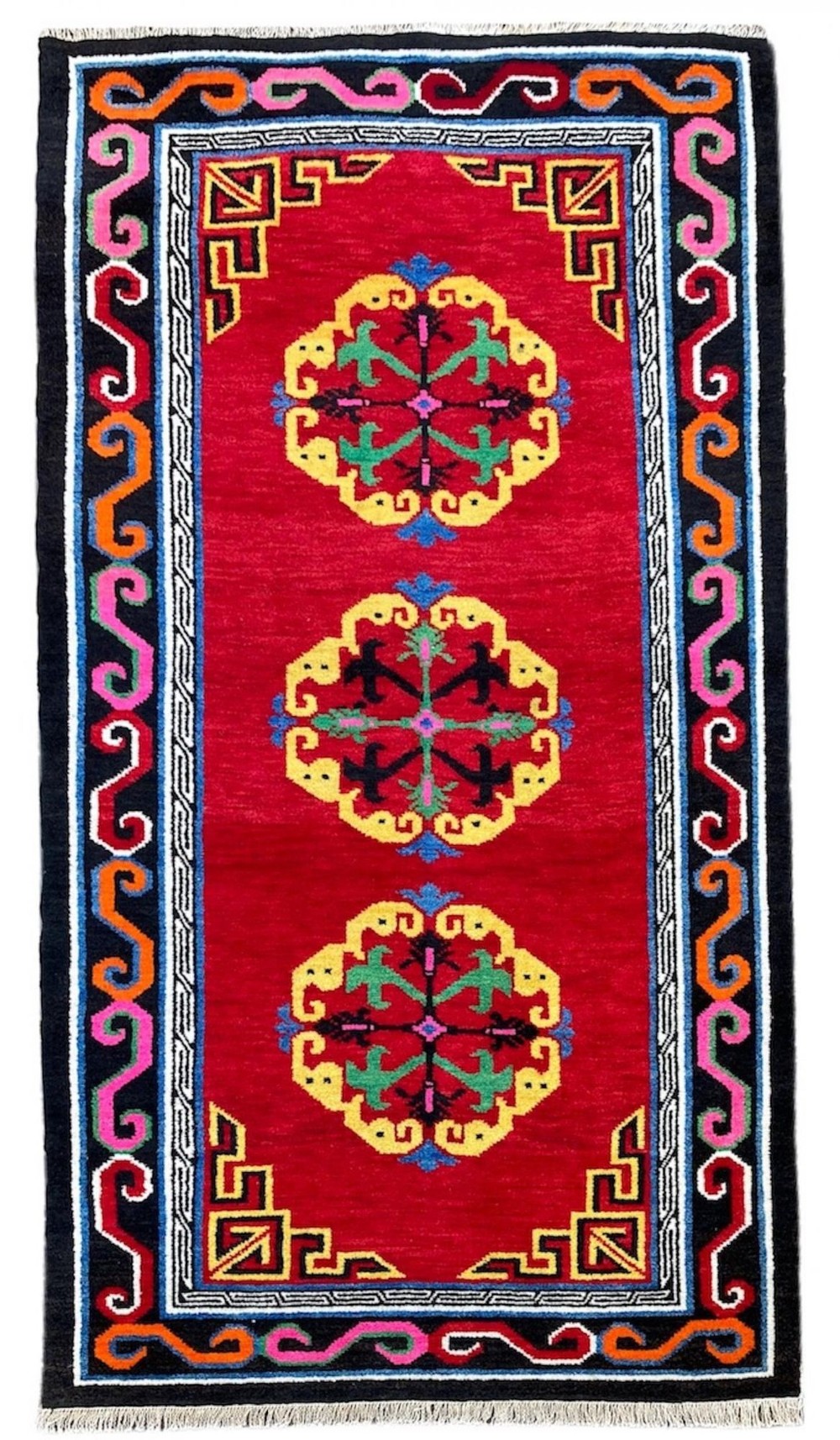 A hand-knotted rectangular Tibetan wool rug featuring a bright red centre field with three yellow and green central medallion motifs framed by a black cloud-scroll border.