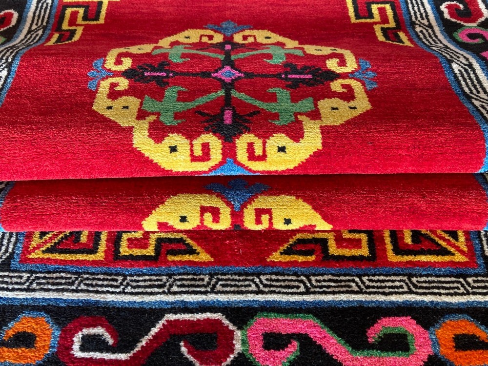 A hand-knotted rectangular Tibetan wool rug featuring a bright red centre field with three yellow and green central medallion motifs framed by a black cloud-scroll border. View XI