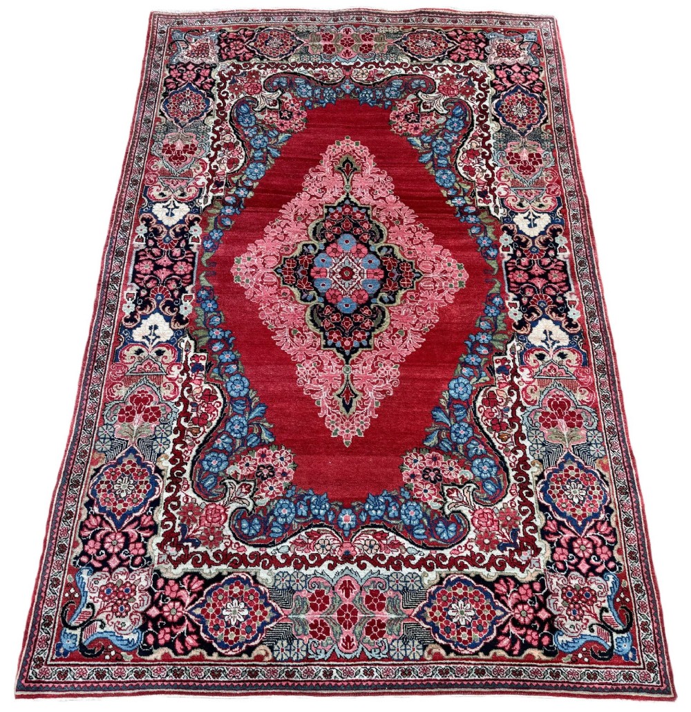 Hand-knotted antique Persian Sarouk wool rug featuring a large central floral medallion on a rich red ground with elaborate decorative borders. View II