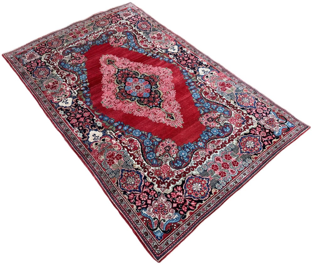 Hand-knotted antique Persian Sarouk wool rug featuring a large central floral medallion on a rich red ground with elaborate decorative borders. View III