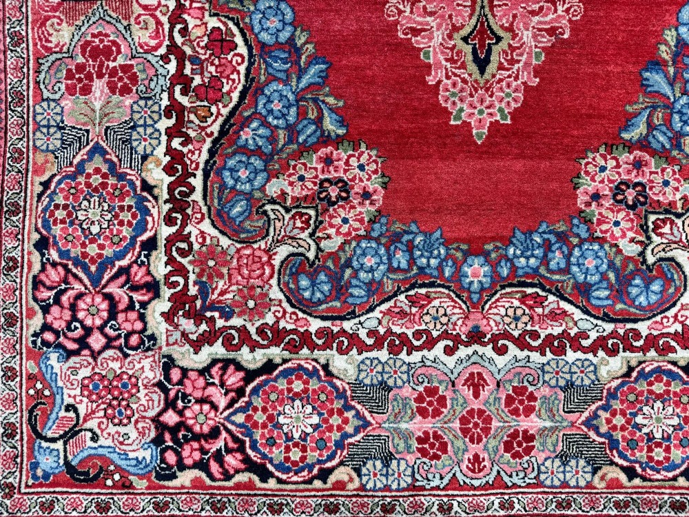Hand-knotted antique Persian Sarouk wool rug featuring a large central floral medallion on a rich red ground with elaborate decorative borders. View VII