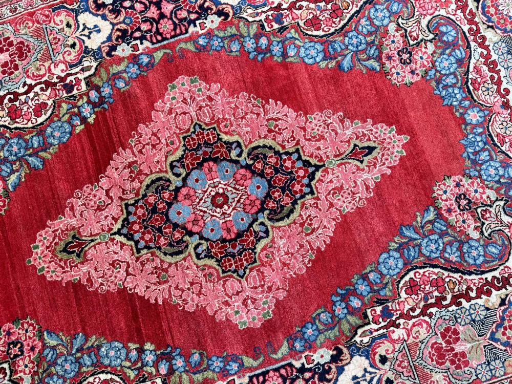 Hand-knotted antique Persian Sarouk wool rug featuring a large central floral medallion on a rich red ground with elaborate decorative borders. View XI