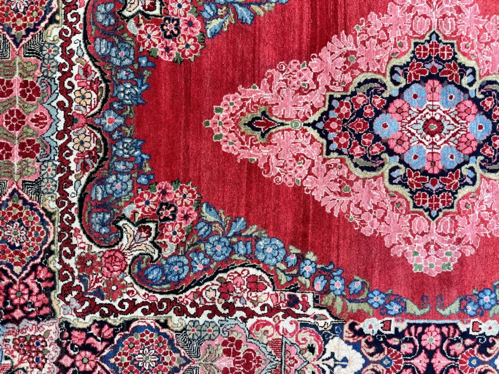 Hand-knotted antique Persian Sarouk wool rug featuring a large central floral medallion on a rich red ground with elaborate decorative borders. View XII